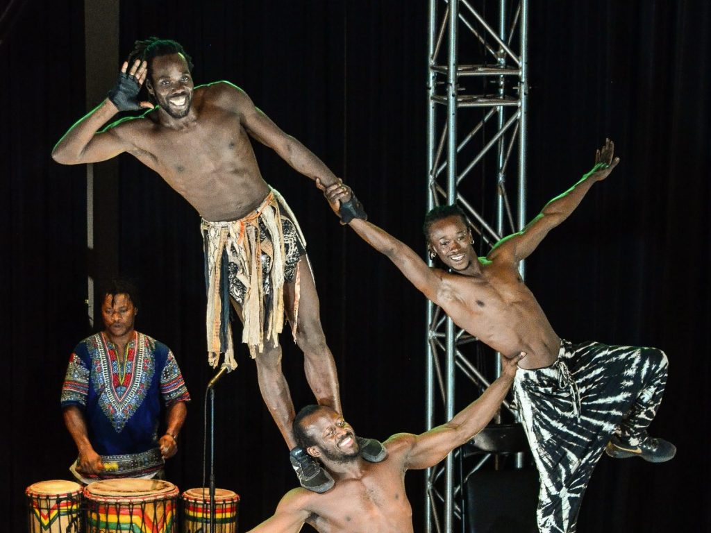 trois acrobates formes un traingle vertigineu avec leur corps