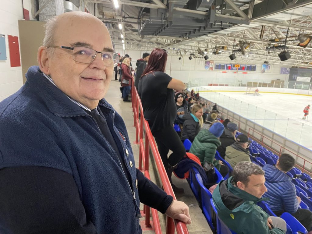 Un homme âgé souriant est une partie de hocket en arrière plan
