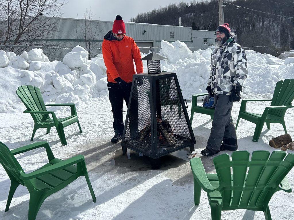 des personne profitant d'un feu extérieur