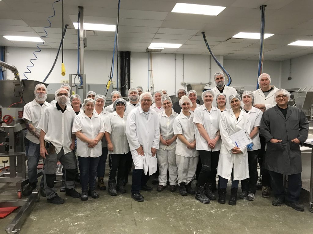 Des gens dans une usine habillés de blanc avec des filets sur la tête